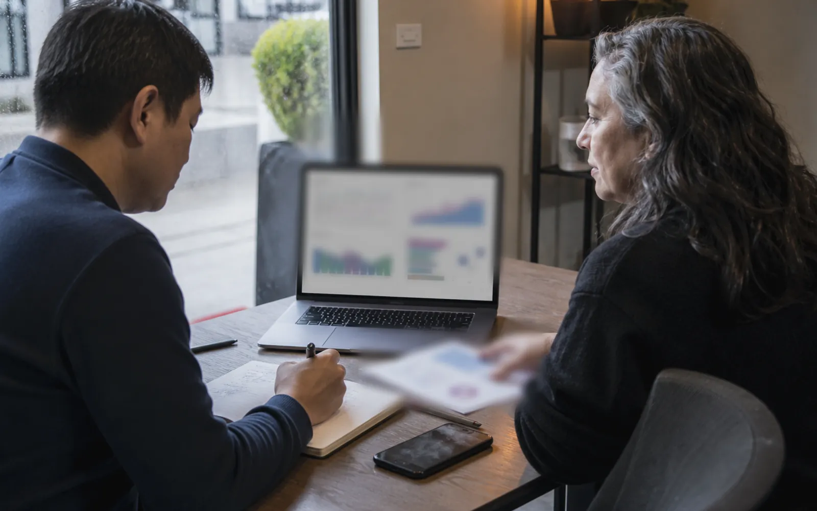 A monthly social media performance report being reviewed beside a content calendar